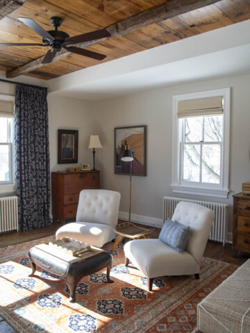 the sitting area in our bedroom painted with Natural Cream on the walls and a peach and indigo carpet and navy blue drapes with oatmeal colored crewel embroidery