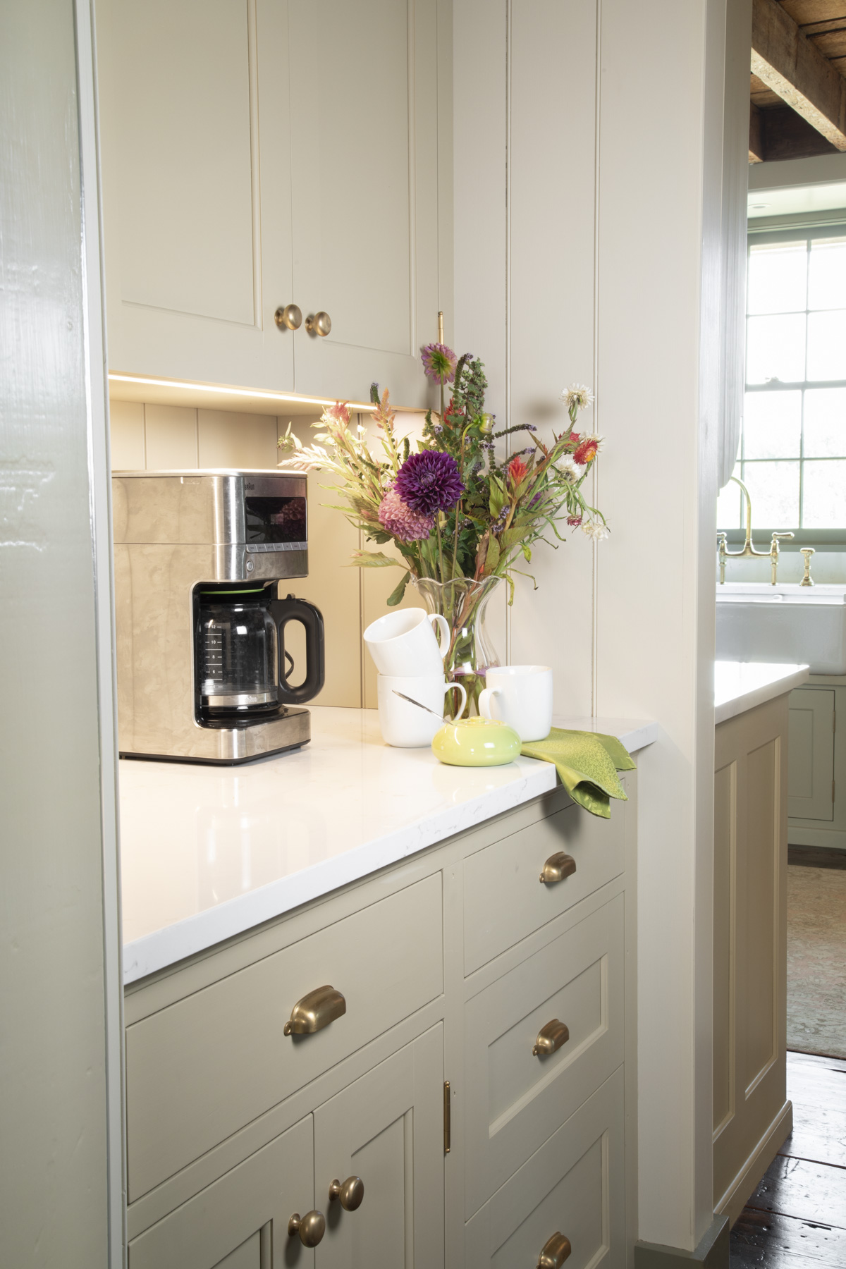 wool skein on the beaded board walls in our kitchen adjacent to the custom cabinets which are painted a darker khaki color called Baffin Island which is another Ben Moore color