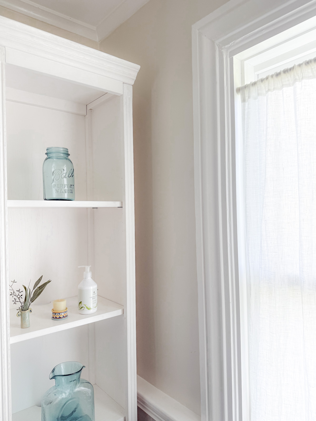 ballet white walls with White Dove trim with a white bookshelf with aqua blue accent decor on it