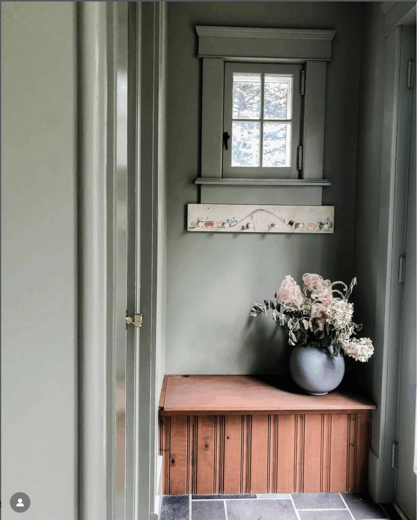 a pop of red on a mudroom bench in a colonial home
