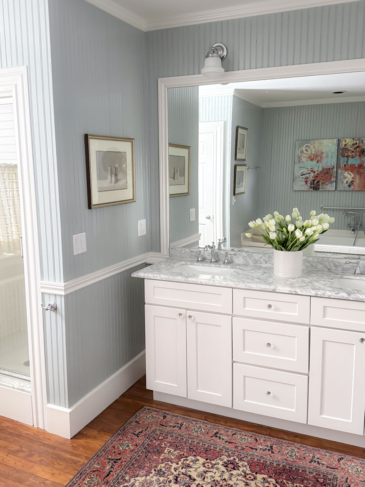beach glass in our primary bathroom with white trim, Carrera marble and a white vanity