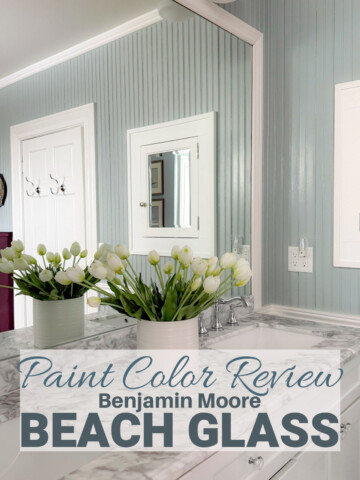 bathroom with bead board walls painted Beach Glass with Carrera Marble vanity top and fresh flowers