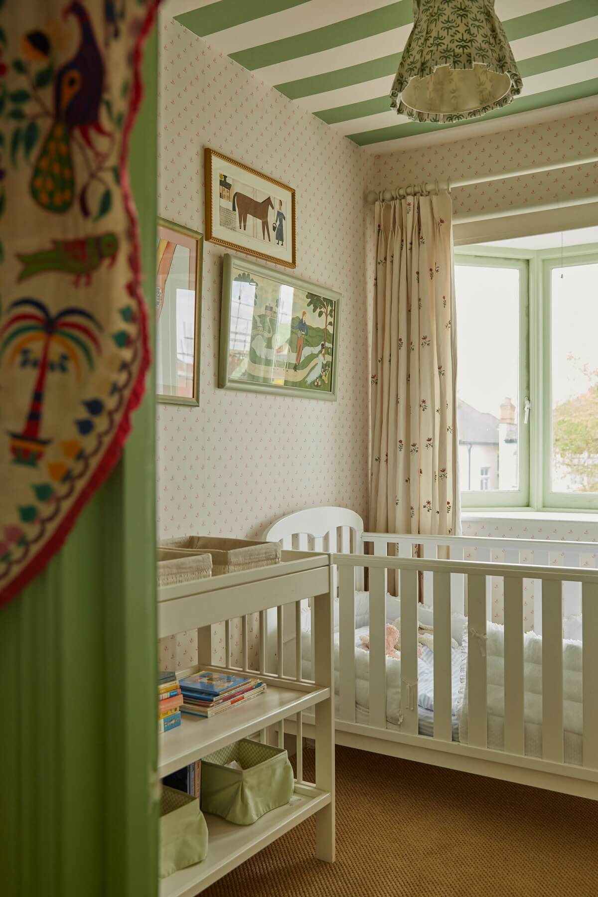 cream and green nursery design with striped ceiling