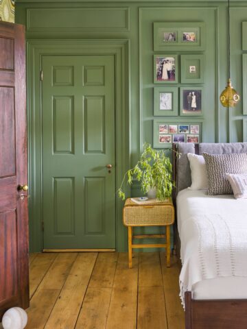 green painted wall behind a bed's headboard