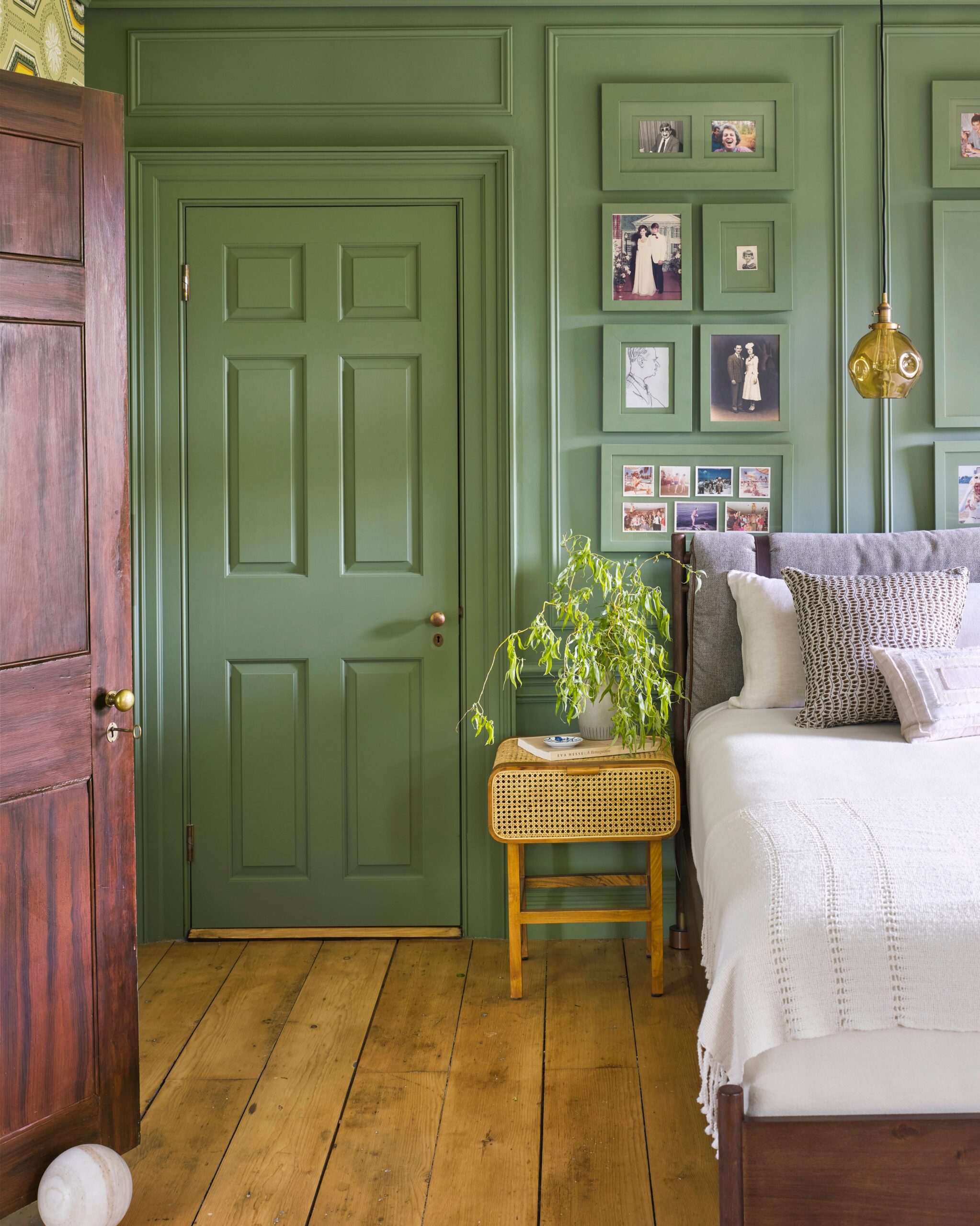 green painted wall behind a bed's headboard