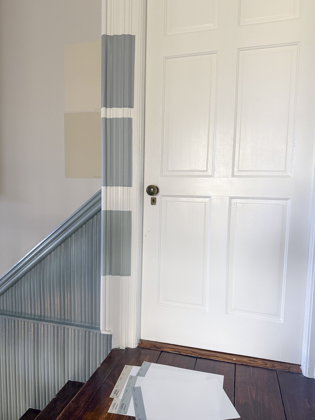 Samplize samples stuck to the wall and trim around a door casing in our stairwell