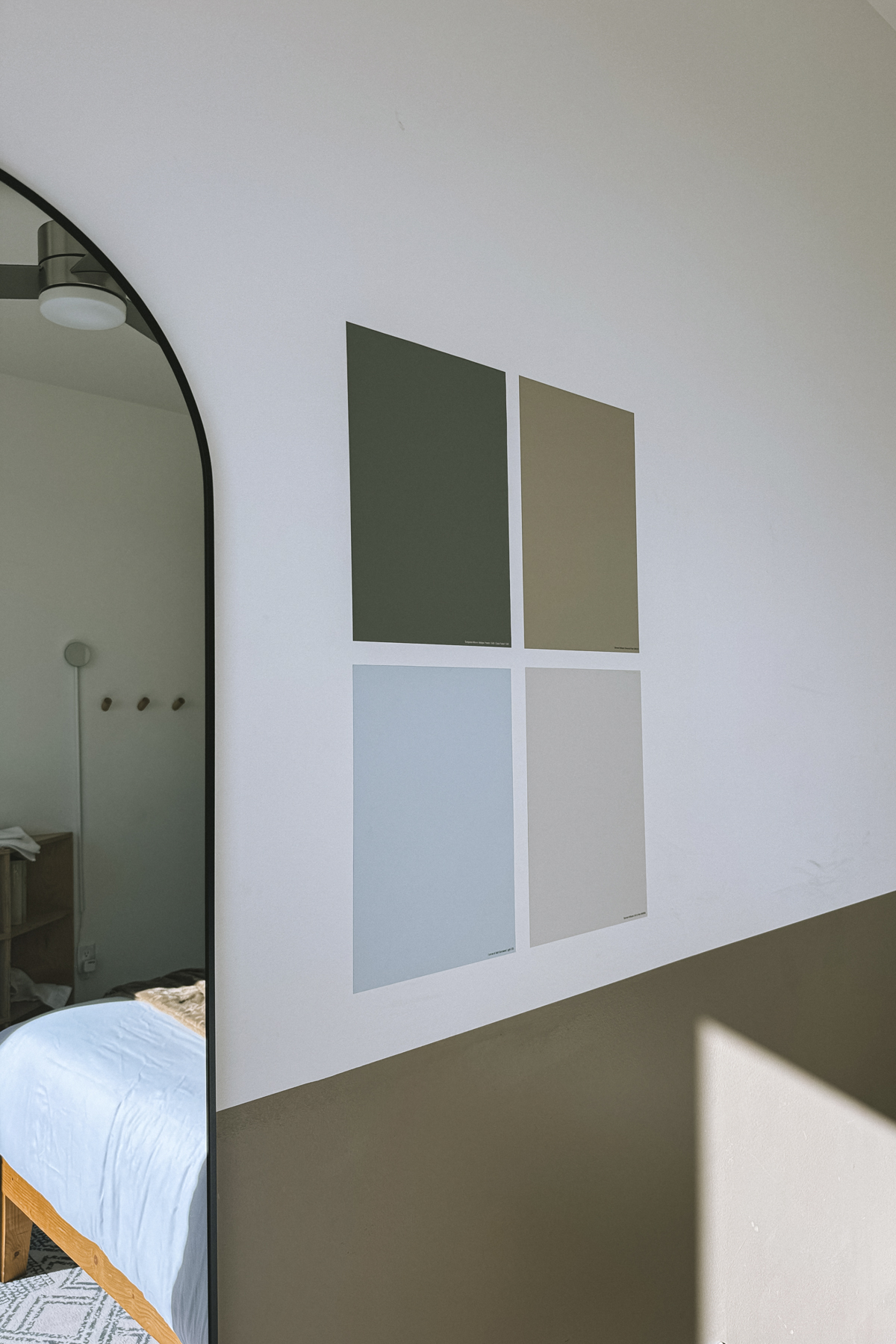 Samplize samples on a white wall with an arched doorway peeking into a bedroom
